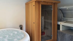 Eine Holzsauna mit Glastür, Whirlpool und Saunaofen.