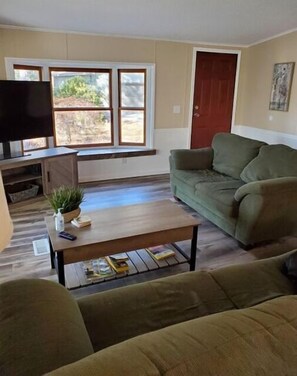 Relax in this inviting living space with a sofa, coffee table, and flat-screen TV.