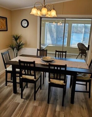 Enjoy meals in this inviting dining area with a large window, a chandelier, and comfortable seating for six.