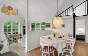 Enjoy meals with family and friends in this dining area, surrounded by a high ceiling and lush views.
