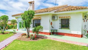 A two-story house with a tiled roof, a small garden, and a statue on the front lawn. - Nice home in La Cala de Mijas (La Cala de Mijas)
