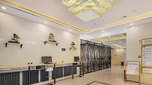 A modern reception area with a reception desk, computer monitors, and a decorative chandelier. - Greentree Inn Beijing Daxing District Huangcun Wes (Daxing)
