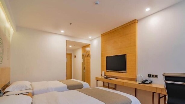 A hotel room with two beds, a wooden desk with a TV, and a chair. - Greentree Inn Beijing Daxing District Huangcun Wes (Daxing)