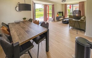 Relax in this open-plan living space with a dining area and seating area, featuring a large dining table and comfortable seating for six.