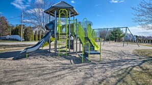 A playground with a slide, climbing structures, and a covered play area.