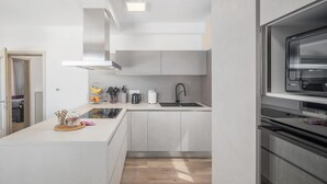 Una cucina moderna con isola centrale, forno a incasso e finestra sopra il lavello.