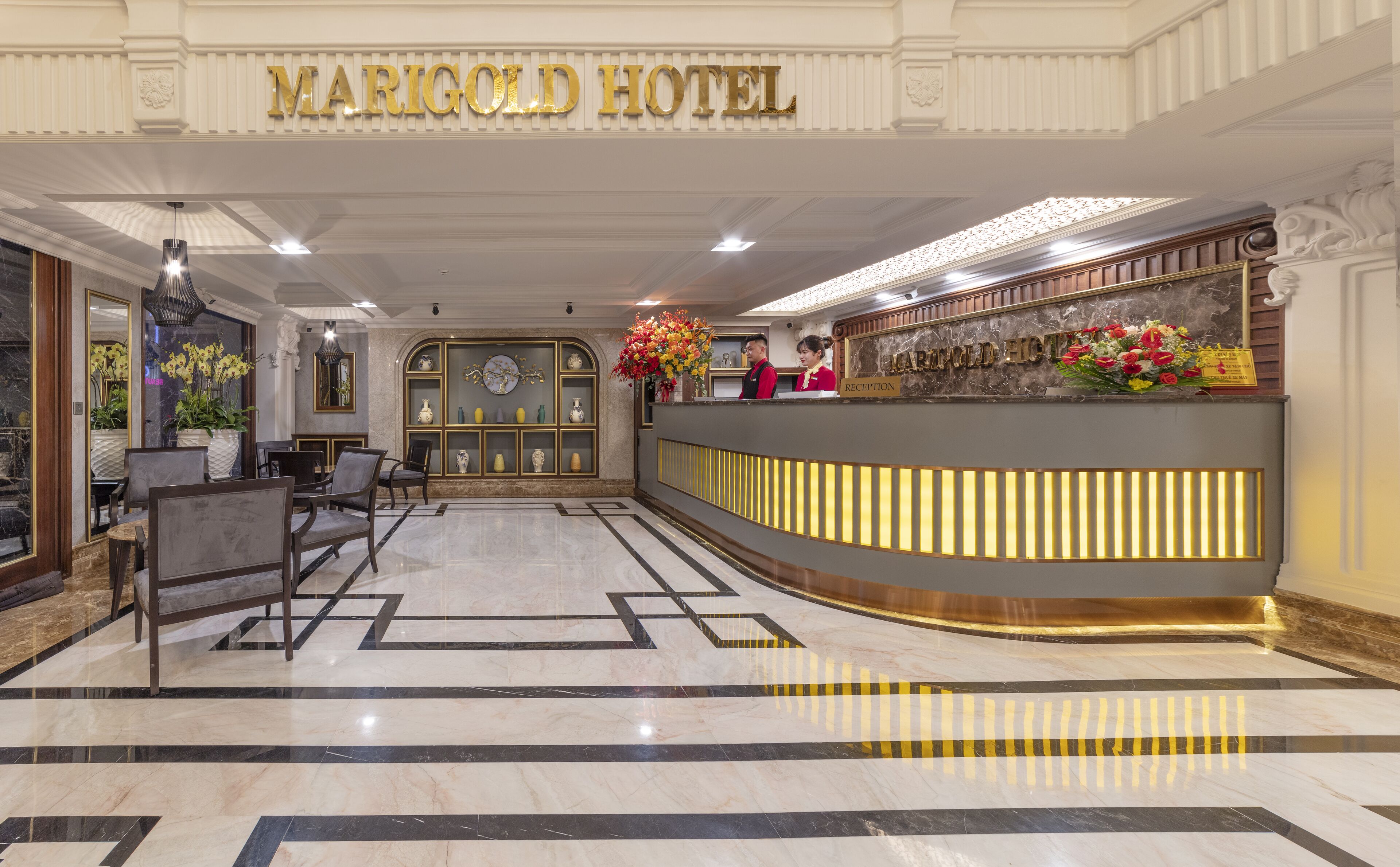 A hotel reception area with a marble floor, reception desk, and a reception sign.