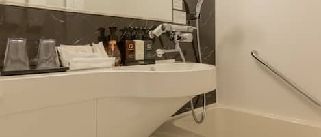 Un bagno moderno con un WC bianco, un lavabo con articoli da toilette, una doccia e un portasciugamani.