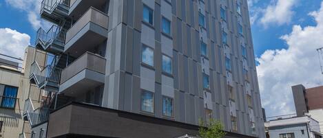 A modern hotel with a multi-story structure, a covered entrance, and a visible outdoor seating area.