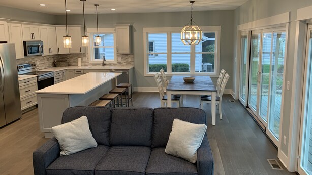 A modern kitchen with white cabinets, stainless steel appliances, and a central island. - Beautiful newer construction 2021 home in town! (Saugatuck)