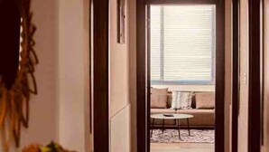 A hallway leading to a living area with a sofa and a coffee table. - Immaculate 2-Bed Apartment at PamV Estates Apt6 (Accra)