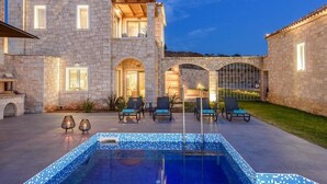 A stone building with a swimming pool, outdoor seating, and a covered patio area. - Caldera Theros Villas (Hersonissos)