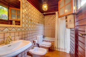 Un baño con lavamanos, bidés, inodoro y bañera.