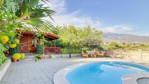 A swimming pool with a stone border, a wooden deck, and a small pavilion with a thatched roof. - Villa Mimosa, mountain views, pool, fast Wi-Fi, garden and terrace; parking available (Arafo)