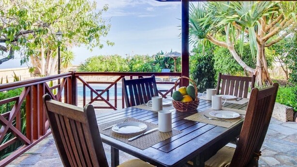 An outdoor dining area with a wooden table, chairs, and a view of the sea. - Villa Mimosa, mountain views, pool, fast Wi-Fi, garden and terrace; parking available (Arafo)