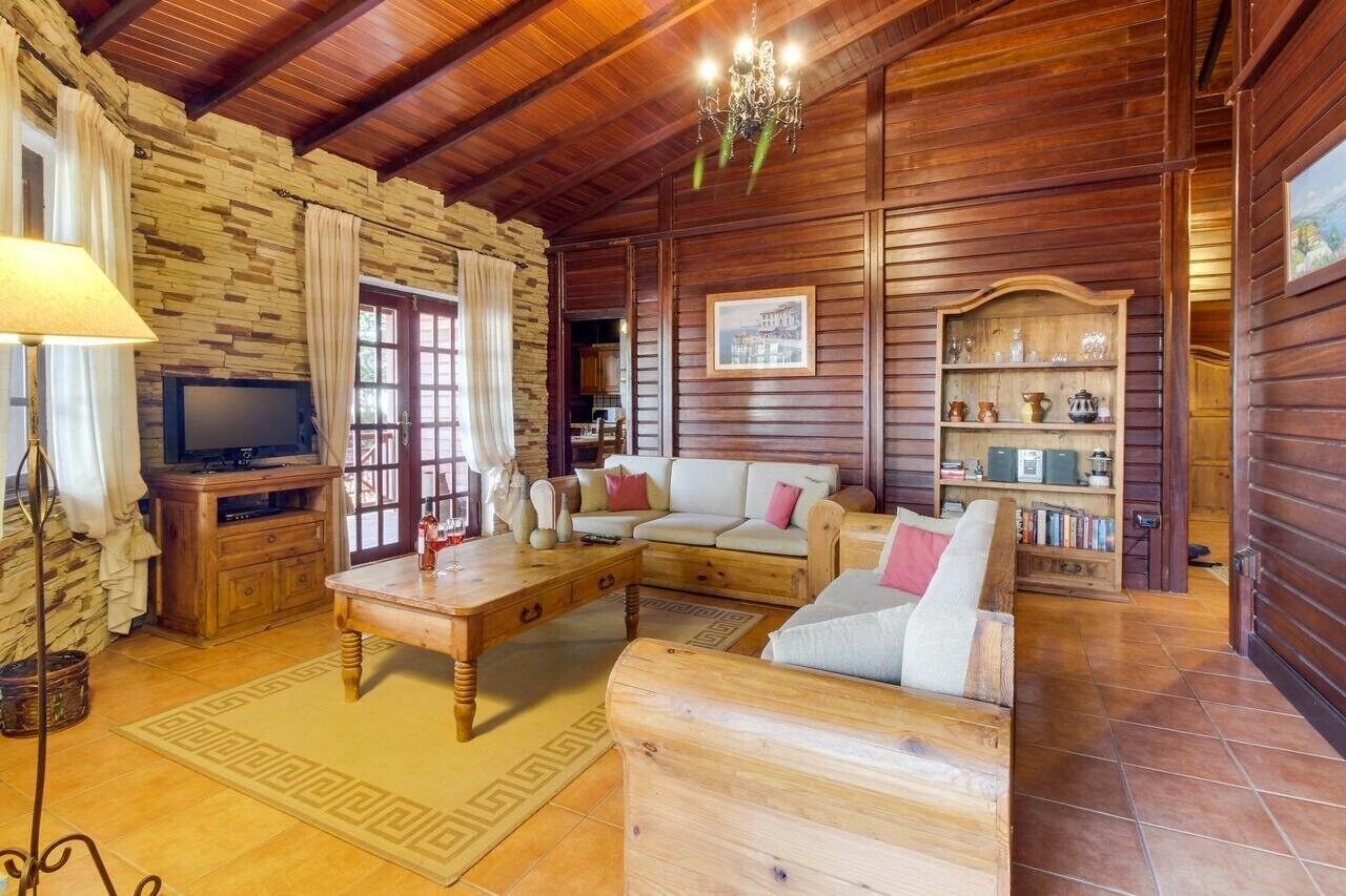 A wooden interior with a sofa, coffee table, and a bookshelf.