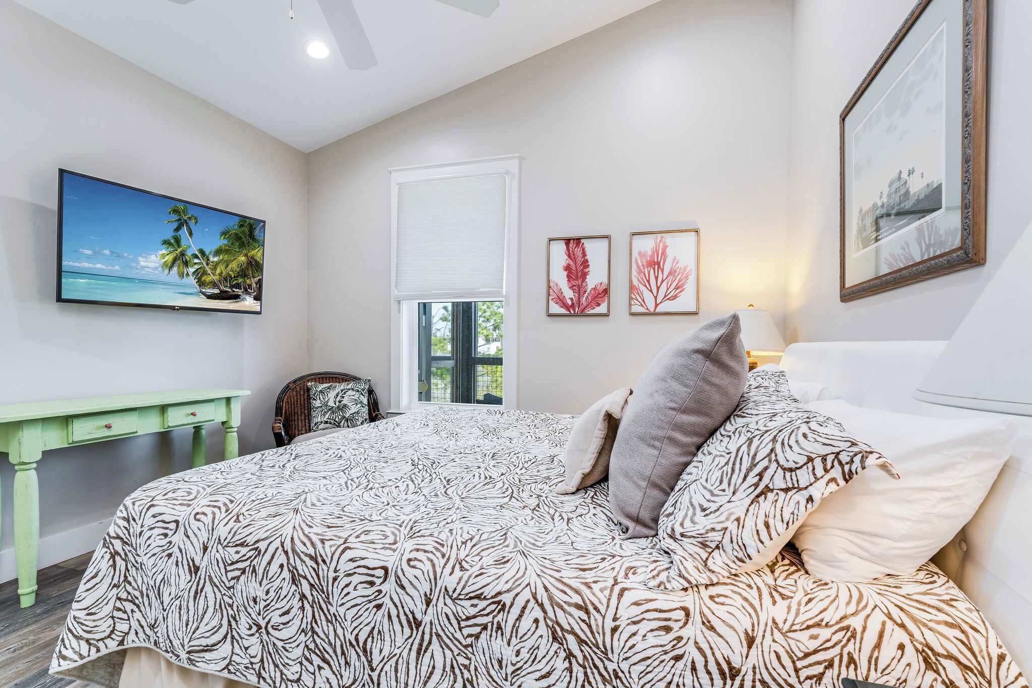 A bedroom with a bed, a desk, and a window.