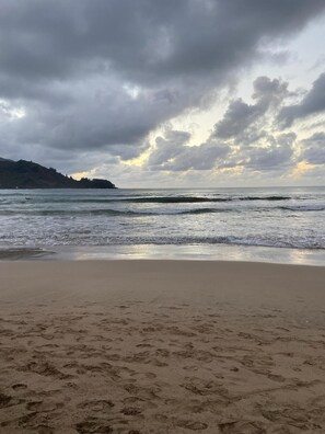A beach with footprints in the sand and a cloudy sky. - Executive Family 4BR Princeville Home by beaches & the park w/AC, SPA and Bikes (Princeville)