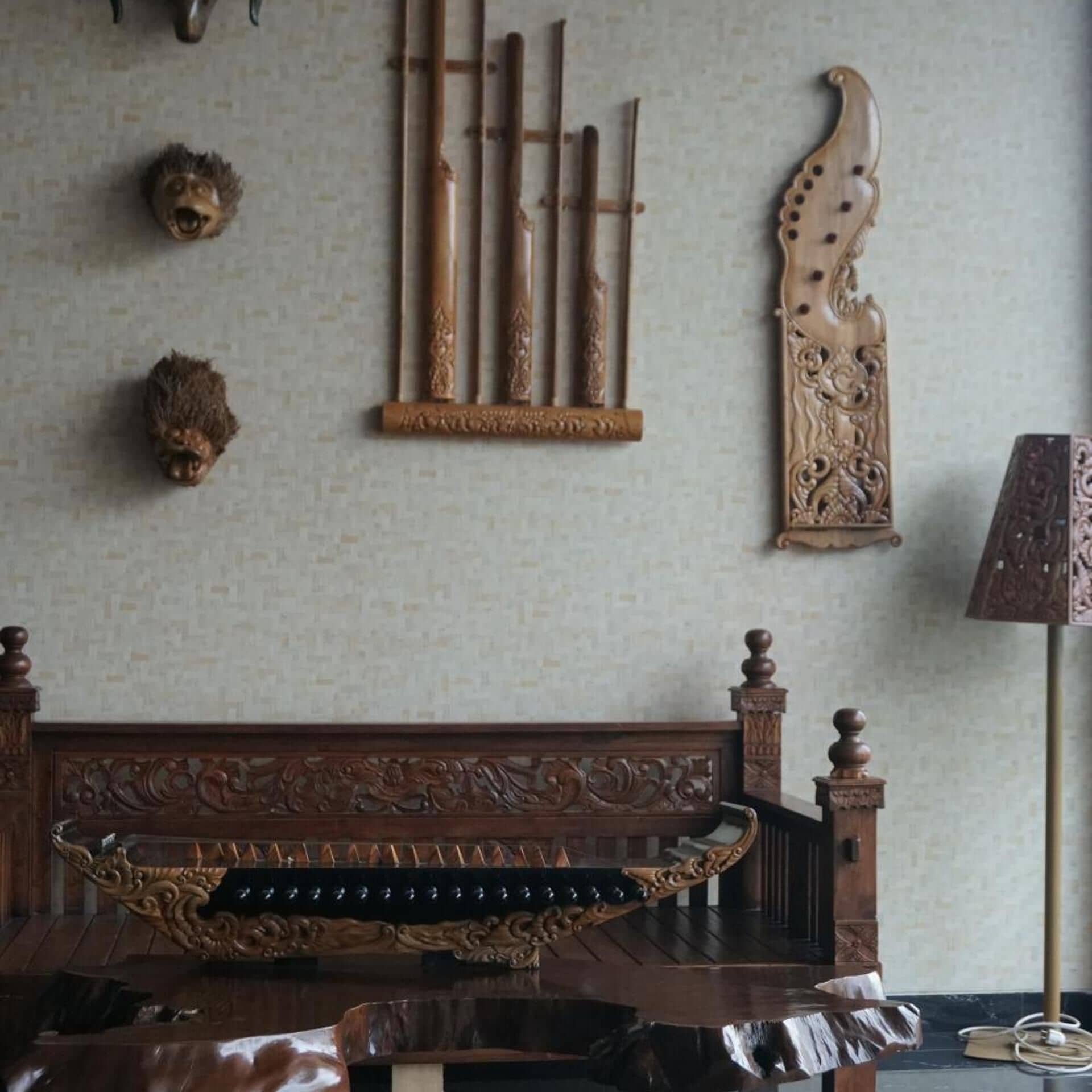 A room with a wooden bed, a traditional stringed instrument, and a decorative wall hanging.
