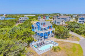 A multi-story residential building with a pool and a view of the ocean. - Soundside Home w/ Private Pool, Game Room, Basketball, and Nearby Beach Access (Avon)