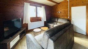 A cozy cabin interior with a sofa, TV, and a small round table. - De Brenkberg by Interhome (Schinveld)