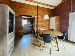 A wooden interior with a dining table, chairs, a kitchen area, and a fire extinguisher. - De Brenkberg by Interhome (Schinveld)