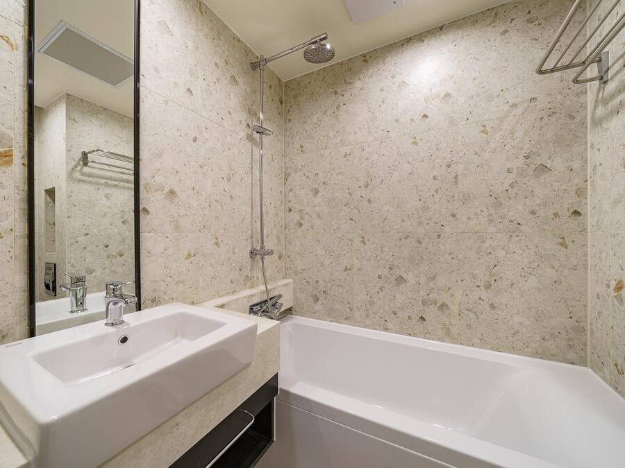 Un baño con dos lavamanos, una bañera y una ducha.