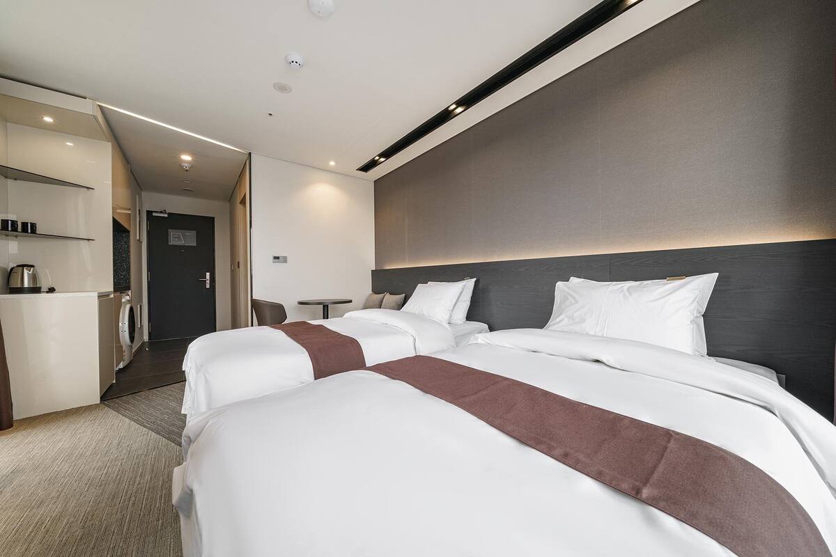 A hotel room with a large bed, a desk with a coffee machine, and a separate bathroom area.