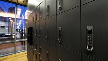 A row of black lockers with a keypad lock, a handle, and a small display screen.
