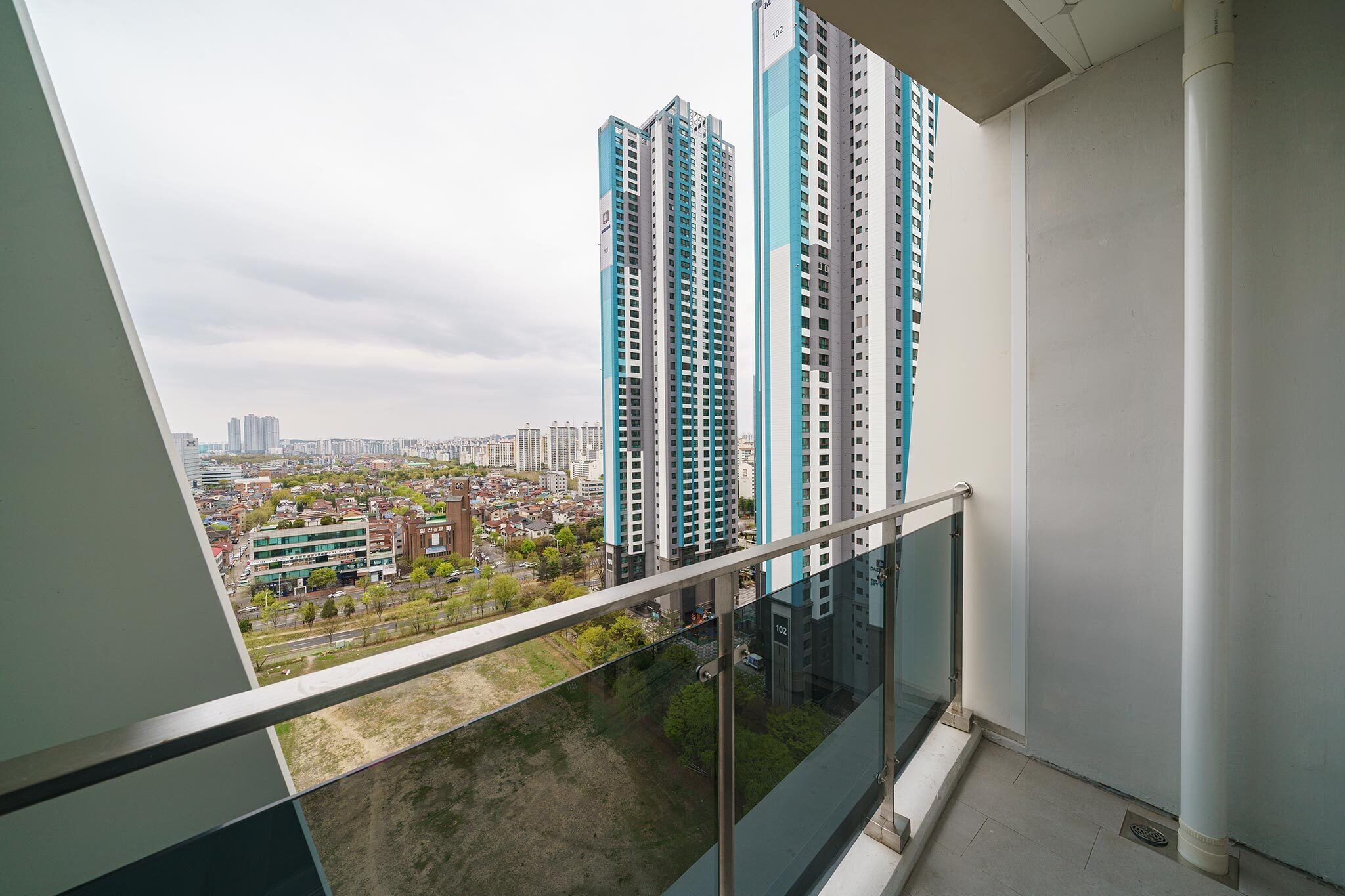 A high-rise building with a glass balcony overlooking a cityscape.