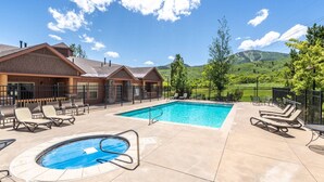 Un hôtel doté d’une piscine, de chaises longues et offrant une vue sur les montagnes.