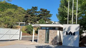 Un edificio moderno con fachada de piedra, entrada protegida por una reja y un cartel que indica que es el Hotel Rákodai, Tábér.