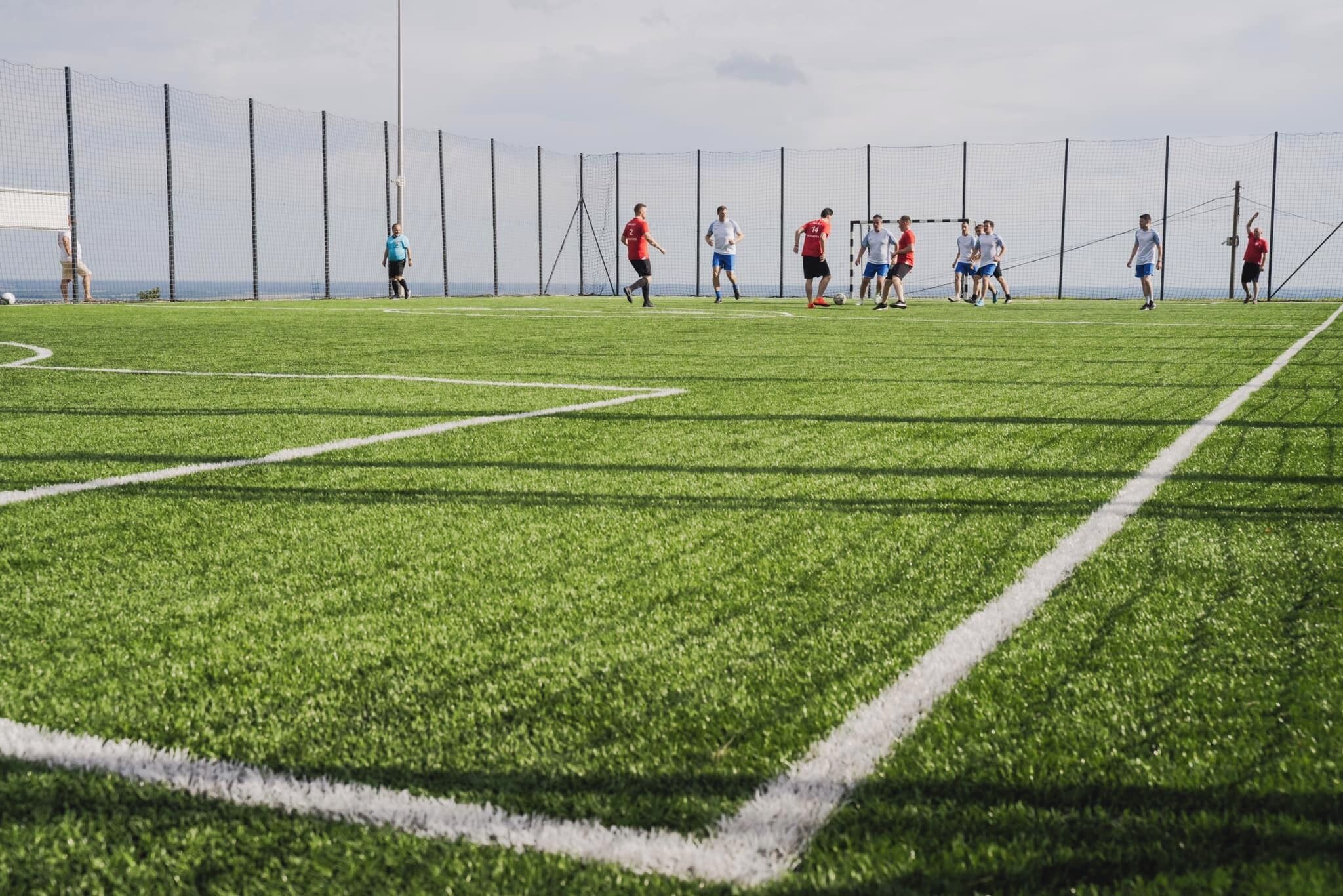 Un campo de fútbol con jugadores con camisetas rojas y blancas.