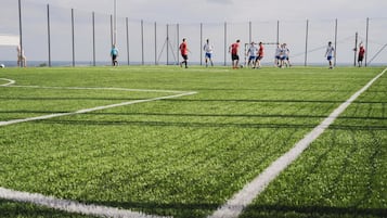 Un campo de fútbol con jugadores con camisetas rojas y blancas.