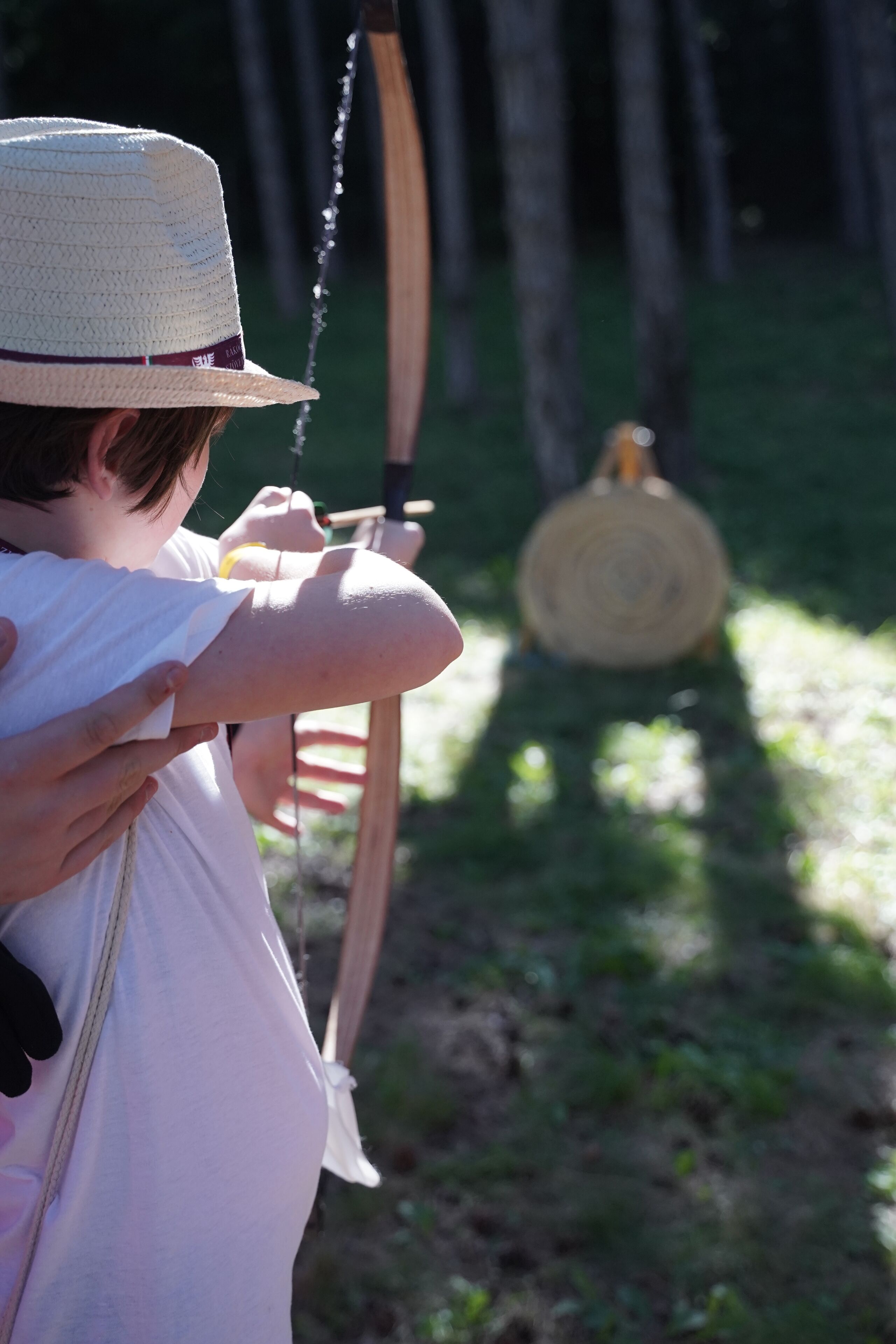 A person aiming a bow at a target.