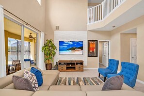 Relax in this stylish living area with a large flat-screen TV, comfortable sofa, and cozy armchair.