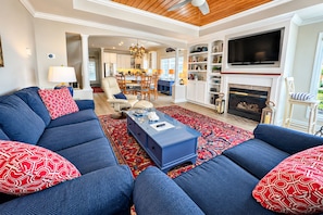 A living room with a blue sofa set, a coffee table, and a fireplace.