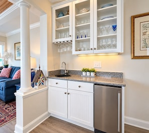 A kitchen with white cabinetry, a stainless steel dishwasher, and a granite countertop.