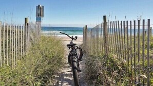 Una bicicleta aparcada a l'entrada d'un camí de mar.