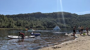 A lake with people on watercraft and a sandy beach. - Fantastic and large cottage on top of Furuåsen in the heart of Sirdal (Tjørhom)