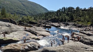 A natural rocky landscape with a river, surrounded by forested hills. - Fantastic and large cottage on top of Furuåsen in the heart of Sirdal (Tjørhom)