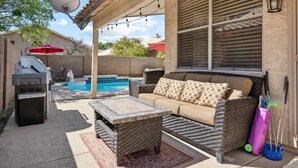 A backyard with a pool, outdoor furniture, a grill, and string lights. - Beautiful n Cozy - Great Location - Private Heated Pool (Chandler)