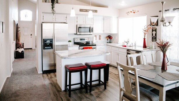 A modern kitchen with white cabinetry, stainless steel appliances, and a central island with stools. - Beautiful n Cozy - Great Location - Private Heated Pool (Chandler)