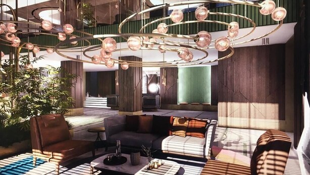 Een moderne lobby met een ronde kroonluchter, zithoeken en een trap naar een hoger gelegen niveau.