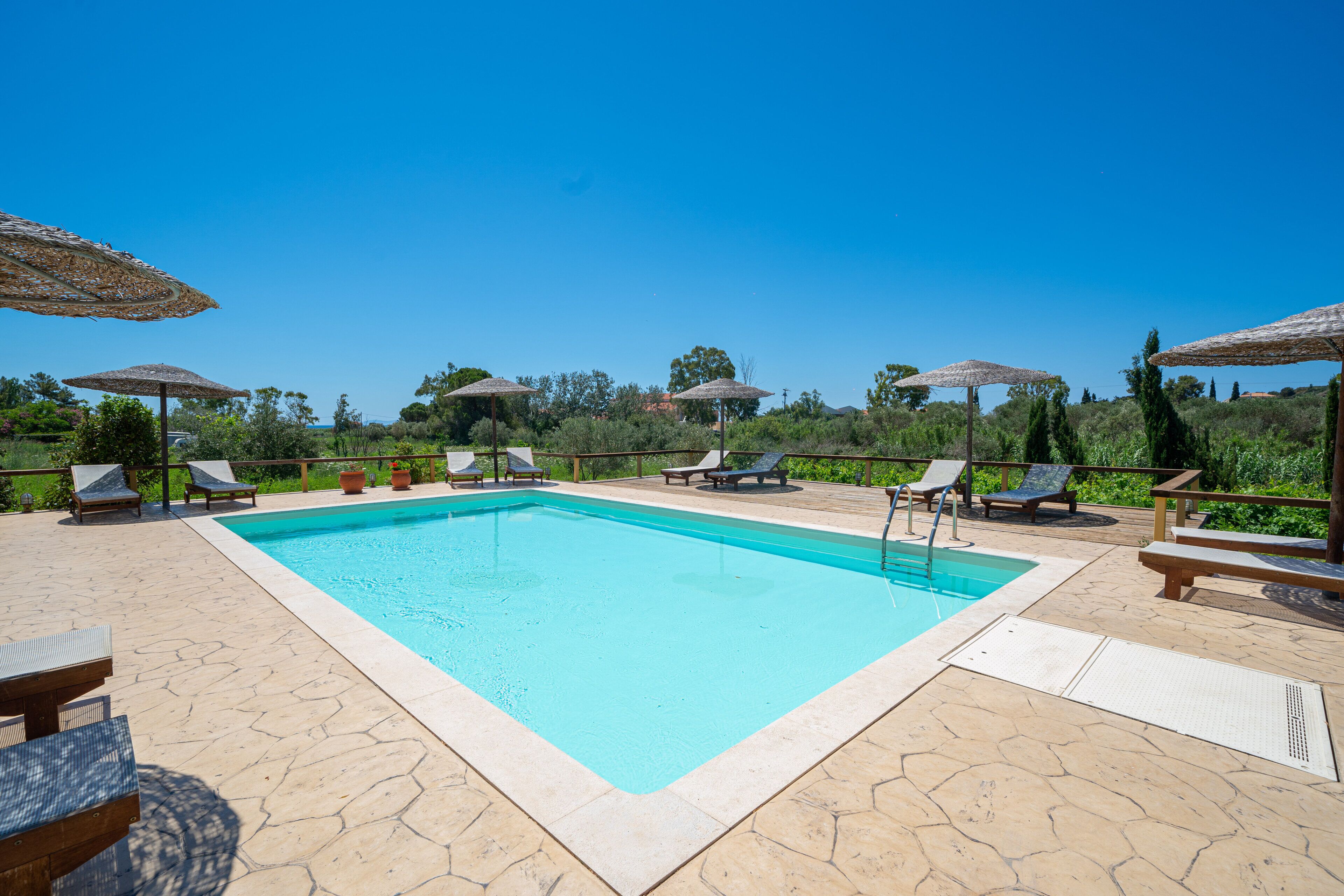 Una piscina al aire libre de temporada, sombrillas