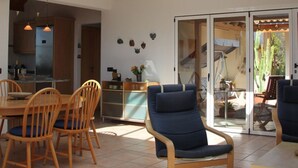 A spacious room with a high ceiling and a skylight, wooden furniture, and a sliding glass door leading to an outdoor area. - Casa de las Estrellas (Los Llanos)
