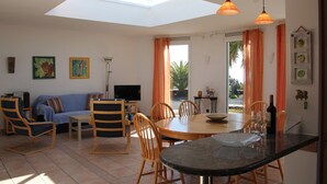 A living room with a sofa, chairs, a TV, and a dining table with chairs. - Casa de las Estrellas (Los Llanos)