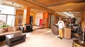 A spacious lobby with a high ceiling, a reception desk, a sofa, and a coffee table.