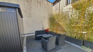 A patio with outdoor furniture, a red pot, and a bamboo plant. - Jaures 2 bedrooms 7 minuts walking from Palais (Cannes)