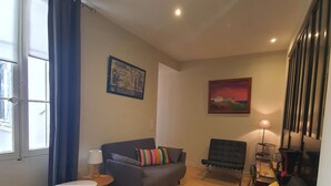 A living room with a grey sofa, a black rocking chair, and a small table. - Jaures 2 bedrooms 7 minuts walking from Palais (Cannes)